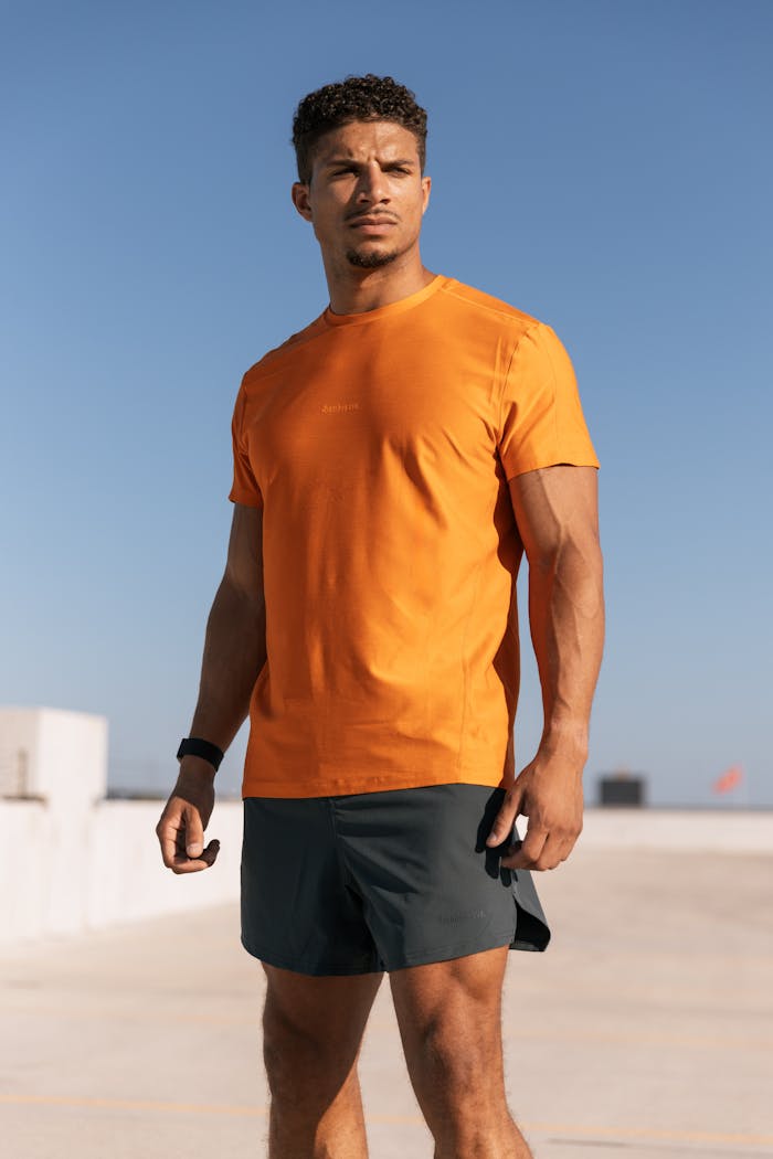 services-04 Man in vibrant athleisure outfit posing on a sunny Austin rooftop.