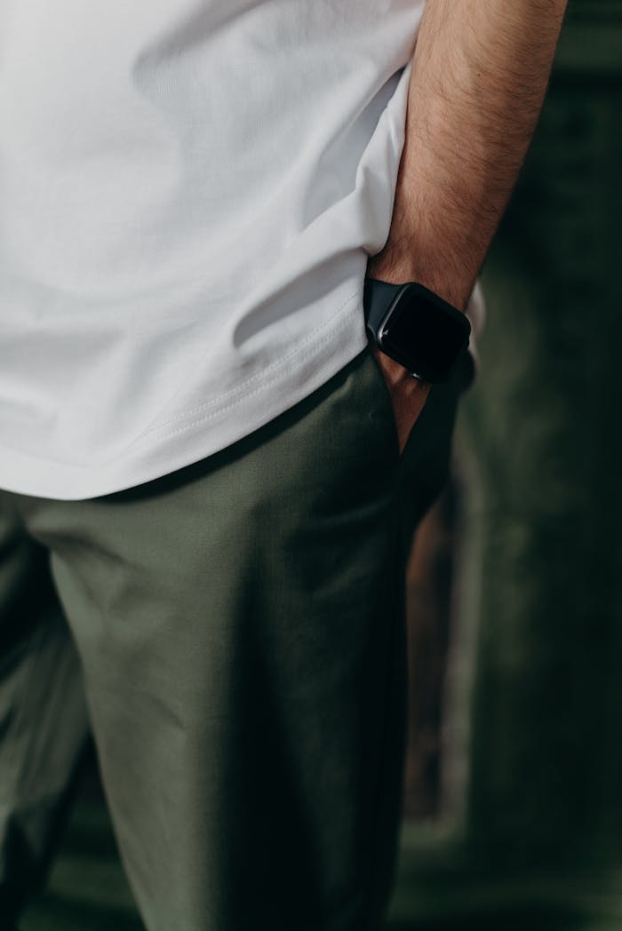 team-03 Close-up of a man wearing a white t-shirt and smartwatch in a casual setting.